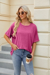 Detail of loose fit magenta crew neck T-shirt with rolled sleeves and casual soft fabric