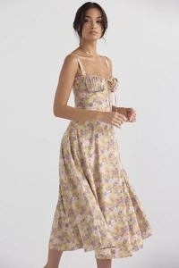 Detailed view of yellow floral midi dress with delicate bow tie and pleated neckline