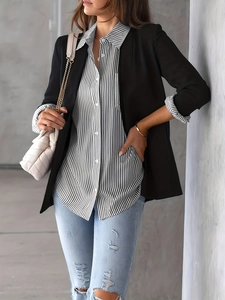 Detail showing vertical striped shirt paired with a black blazer and light blue ripped jeans