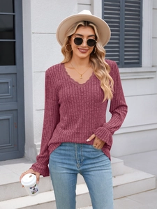 Close-up of V-neck dusty rose ribbed knit top with elegant scalloped lace trim detailing