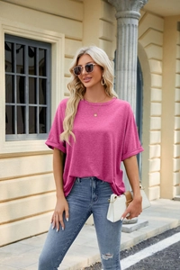 Detail of loose fit rose pink T-shirt with rolled sleeves and round neck on a model