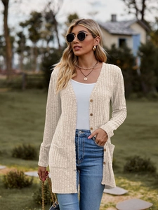 Detail of beige ribbed cardigan with wooden buttons and large front pockets in outdoor setting