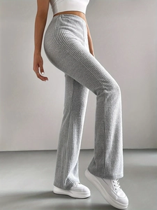 Detail of grey ribbed knit flare pants highlighting high-waist fit and fabric texture