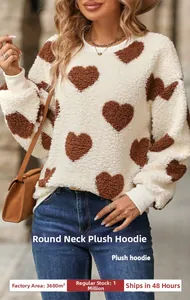 Détail d'un sweat en polaire crème avec motifs de cœurs marrons et poignets côtelés