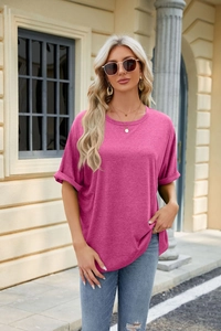 Detailed view of the rose red loose-fit t-shirt showing rolled cuffs and cotton blend texture