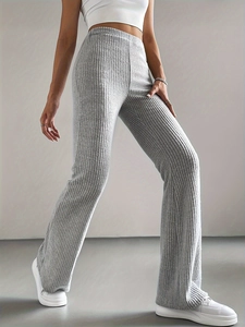 Detailed texture of grey rib-knitted fabric showing high elasticity and drape of trousers