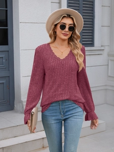 Detail of V-neck ribbed burgundy top showing delicate lace trim and ruffled cuffs style