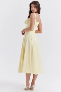 Detail of light yellow midi dress featuring a drawstring neckline and pleated bodice texture