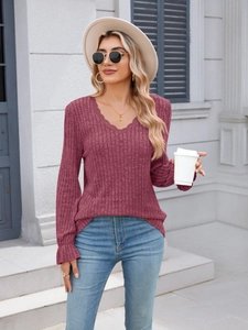 Detailed close-up of V-neckline with lace trim on ribbed knit long sleeve top in wine red