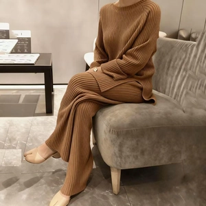 Détail d'un ensemble en maille camel avec pull fendu et pantalon large à côtes fines