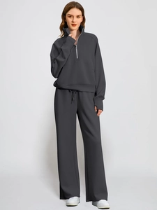Detail of dark grey two-piece tracksuit with stand collar and wide-leg trousers