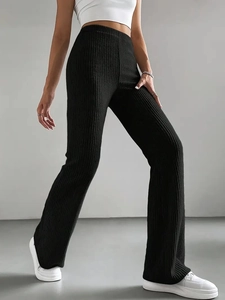 Close-up of black ribbed knit flare pants highlighting the vertical texture and high waist