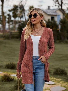 Detail of rust red knit cardigan featuring wood buttons and ribbed texture fabric