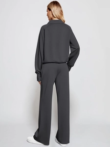 Rear view of dark grey oversized tracksuit featuring wide-leg pants and drawstring hoodie