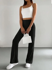 Detail of black ribbed knit flare pants with high waist and vertical texture fabric