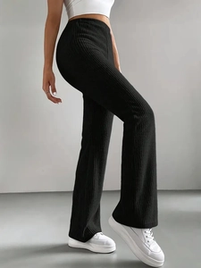 Side view of black ribbed knit flare trousers showing slim fit and textured fabric