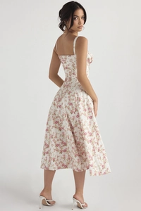 Detail eines weißen Sommerkleides mit lila Blumendruck und eleganten breiten Trägern