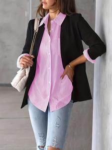 Detail of pink striped shirt under a black blazer with blue distressed jeans and a chain bag