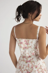 Detail of white summer strap dress with pink floral pattern and square neckline