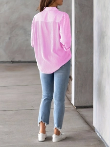Detail view of pink and white striped loose button shirt with a curved hemline