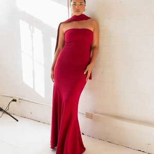 Detail of dark red knitted strapless dress featuring fine ribbed texture and matching shawl