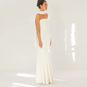Detail of white strapless fishtail dress featuring vertical pleats and matching scarf
