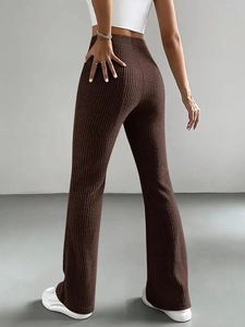 Detail of deep brown ribbed knit flare pants showing slim fit texture and high waist