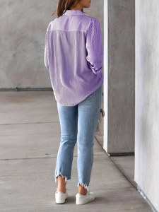 Detail shot of purple vertical striped shirt paired with frayed hem light blue denim jeans