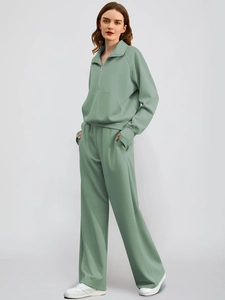 Detail view of sage green two-piece sweatshirt set with wide-leg pants and half-zip design