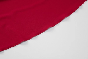 Detail of red textured fabric with professional ruffle edge and precision stitching