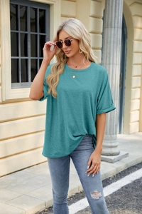 Detail of teal crew neck loose T-shirt paired with denim for a casual street style look