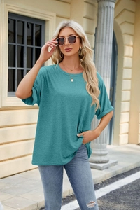 Detail of teal crew neck t-shirt featuring rolled cuffs and subtle melange fabric texture