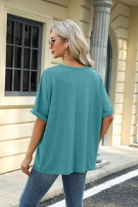 Back view of teal loose-fit short sleeve T-shirt with crew neck and rolled cuff details