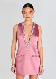 Detalle del vestido satinado rosa con strass brillantes en el escote en V y los bolsillos