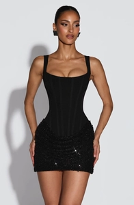 Detalle de corpiño tipo corsé con minifalda de lentejuelas en un vestido de fiesta negro