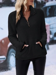 Close-up of black fuzzy fleece sweatshirt with silver ring zipper and cozy collar detail