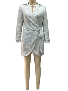 Close-up of silver sequined wrap dress with elegant V-neck and sparkling waist tie detail