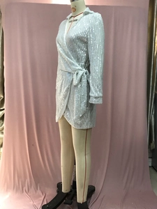 Detail of silver sequined mini dress featuring V-neckline and waist tie decoration