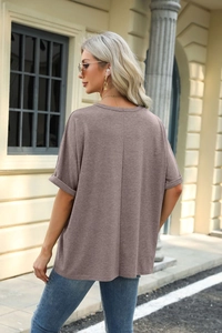 Detail view of brown loose T-shirt featuring vertical back seam and rolled cuff sleeves