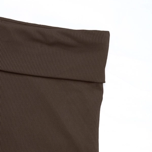 Gros plan détaillé du tissu en maille côtelée marron foncé montrant la texture douce