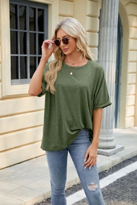 Outdoor street style view of woman wearing a loose dark green crewneck cotton T-shirt