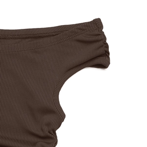 Détail du tissu côtelé marron foncé montrant l'élasticité et le design froncé latéral