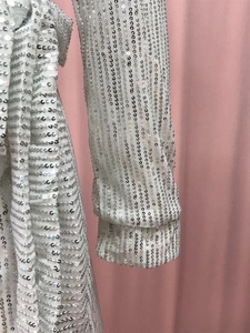 Close-up of sparkling silver sequins in vertical stripes on a sexy V-neck party dress