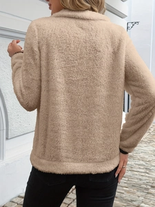 Detail of warm beige plush fleece fabric texture on back of women half zip sweatshirt