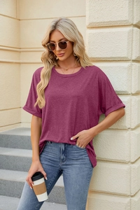 Detail of loose fit crew neck T-shirt featuring rolled cuffs and dark mauve cotton fabric