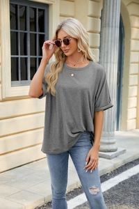 Detail of grey oversized T-shirt with rolled cuffs and round neck in casual outdoor setting