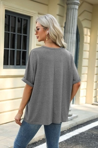 Detail view of the back seam and fixed rolled sleeves on a gray loose fit cotton T-shirt