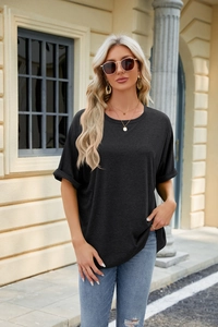 Detail of loose dark grey t-shirt with crew neck and rolled sleeves worn outdoors