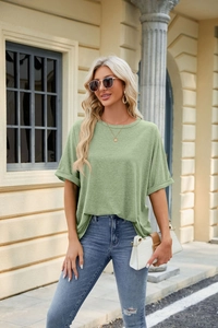Detail of light green loose fit T-shirt featuring classic crewneck and rolled cuffs