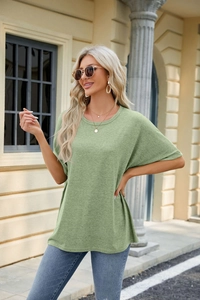 Detail of loose-fit moss green crew neck T-shirt with textured knit fabric on model